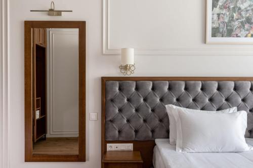 a bedroom with a large mirror and a bed with white pillows at Villa Flavia Heritage Boutique Hotel in Plovdiv