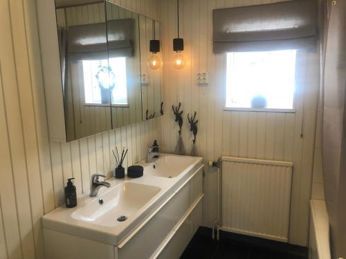a bathroom with two sinks and a mirror at Cozy Villa Close To Lake And Wintersport in Mörsil