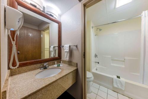 a bathroom with a sink and a toilet and a mirror at Baymont by Wyndham Springfield South Hwy 65 in Springfield