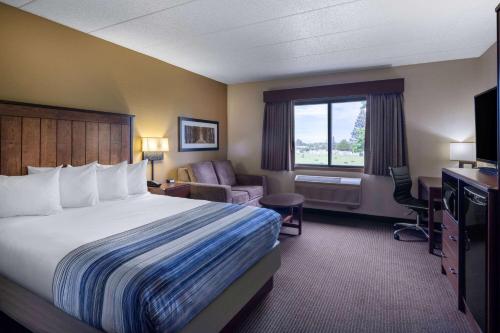 a hotel room with a bed and a desk at AmericInn by Wyndham Two Harbors Near Lake Superior in Two Harbors