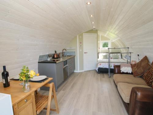 a room with a kitchen and a living room with a couch at Cherry Pod in Shrewsbury