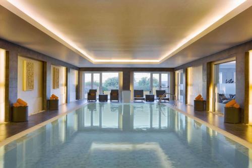 a swimming pool in a building with a conference room at Dolce CampoReal Lisboa in Turcifal