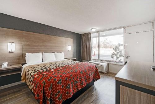 a hotel room with a bed and a large window at Econo Lodge Inn & Suites Near Bricktown in Oklahoma City