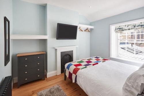 a bedroom with a bed and a tv on the wall at Host & Stay - The Old School House in Pickering