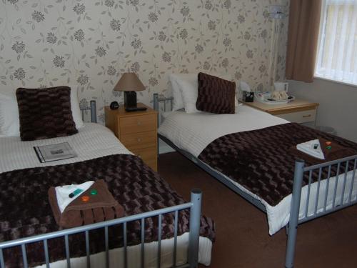 um quarto com 2 camas e uma janela em Atlantis Hotel em Blackpool