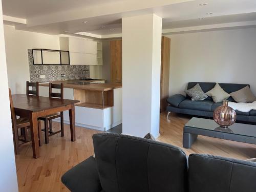 a living room and kitchen with a couch and a table at Moderne, ruhige Ferienwohnung , ideal zum Abschalten in Hadamar
