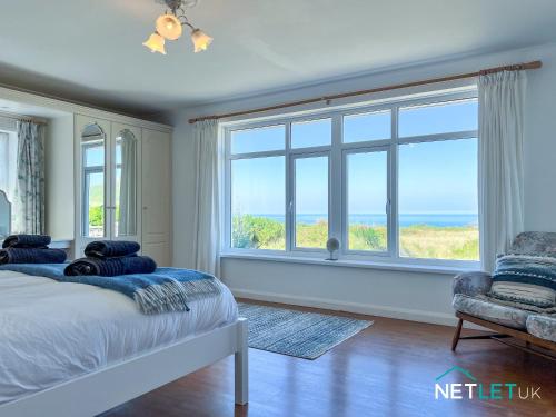 a bedroom with a bed and a large window at Island View in St. Davids