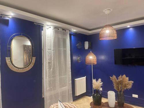 niebieski pokój z lustrem i stołem w obiekcie L'AMAZONIE - Lovely apartment near to the train station and Orly Airport w mieście Juvisy-sur-Orge