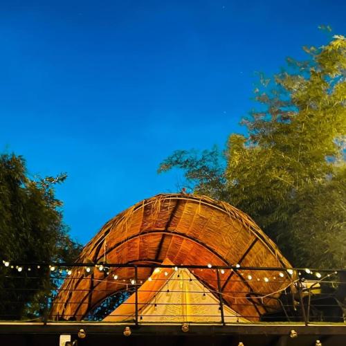 a round wooden building with a blue sky in the background at JK Riverview Resort in Ban Song Phi Nong