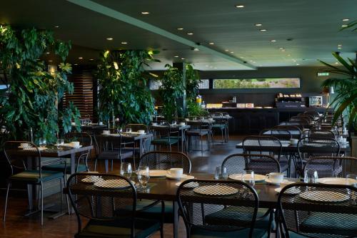 a restaurant with tables and chairs and plants at Hotel Castillo de Gorraiz&Spa in Gorraiz