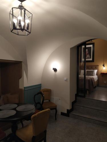 a room with a bed and a table and chairs at Pokoje Nad Arkadami in Zamość