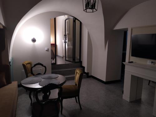a living room with a table and chairs and a tv at Pokoje Nad Arkadami in Zamość