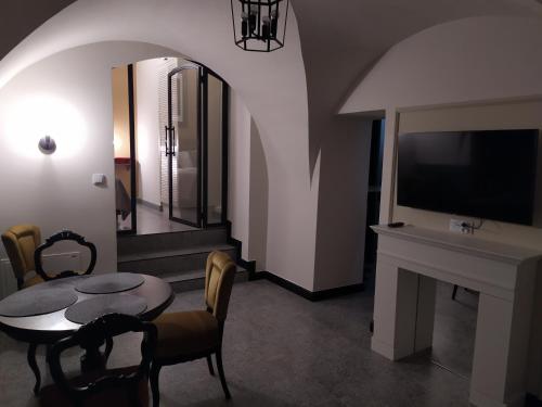 a living room with a table and a tv at Pokoje Nad Arkadami in Zamość