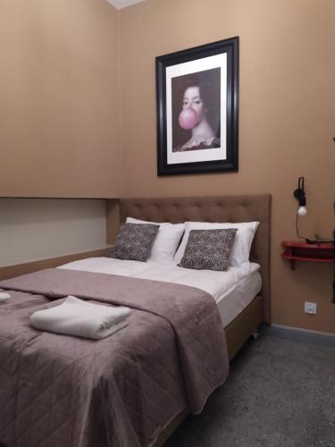 a bedroom with two beds and a picture on the wall at Pokoje Nad Arkadami in Zamość