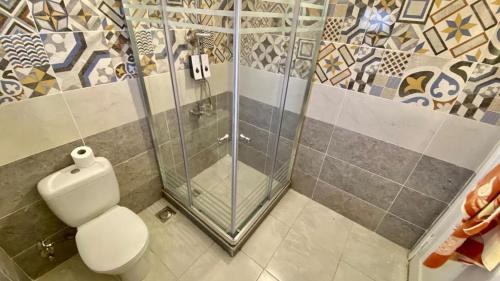 łazienka z toaletą i prysznicem w obiekcie Encanto getaway w mieście Sheikh Zayed
