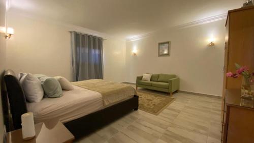 1 dormitorio con cama y sofá en Encanto getaway en Sheikh Zayed