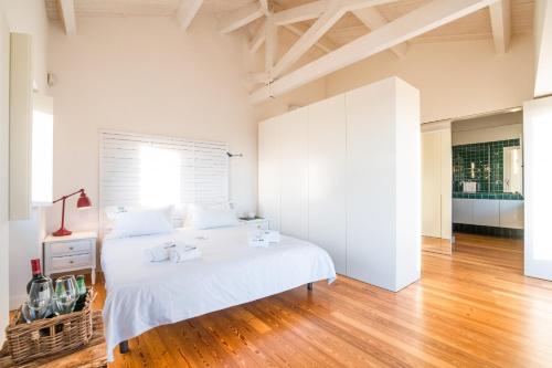 1 dormitorio con cama blanca y suelo de madera en Portugal Active Atlantic Lodge -SEA VIEW -Premium, en Afife
