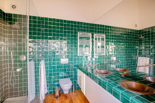 baño de azulejos verdes con 2 lavabos y ducha en Portugal Active Atlantic Lodge -SEA VIEW -Premium, en Afife