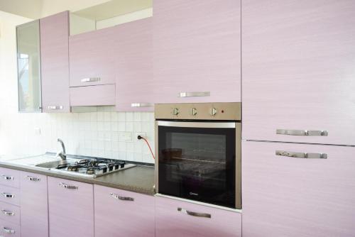 una cocina con armarios rosas y horno. en Appartamento Sea View Adriana, en Marina di Campo