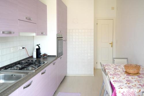 a kitchen with white cabinets and a counter top at Appartamento Sea View Adriana in Marina di Campo