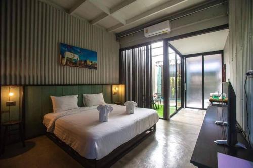 um quarto com uma grande cama branca e uma porta de vidro deslizante em THE TREE Sleep and Space em Trang
