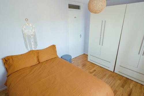 1 dormitorio con 1 cama y armarios blancos en Portobello Corner, en Londres