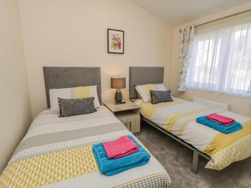 a bedroom with two beds with towels on them at Brighter Daze in Bridlington