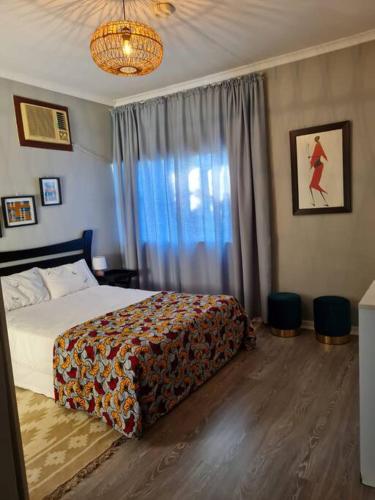 um quarto com uma cama e uma grande janela em African Cycad Holiday Home em Durban