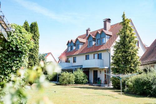 een groot wit huis met een rood dak bij Appartementanlage Marianne in Merkendorf