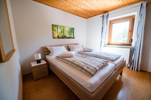 Schlafzimmer mit einem großen Bett und einem Fenster in der Unterkunft Appartementanlage Marianne in Merkendorf