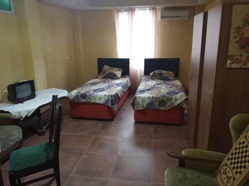Camera con 2 Letti, tavolo e TV di Gostevoi dom Batumi. a Batumi