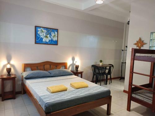 a bedroom with a bed with two yellow towels on it at Villa Skanderbeg Guest House in Puerto Princesa City