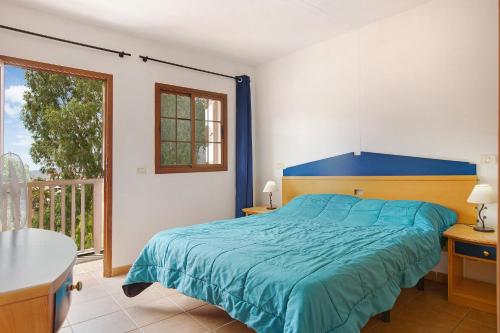 a bedroom with a blue bed and a balcony at Holiday Cottage Santa Lucía 1 in Santa Lucía