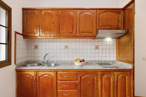 eine Küche mit Holzschränken und einem Waschbecken in der Unterkunft Holiday Cottage Santa Lucía 2 in Santa Lucía