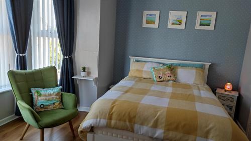 una camera con letto e sedia verde di Luxury 3 bedroom house with peaceful garden, sleeps 6 and 2 mins to beach a Bundoran