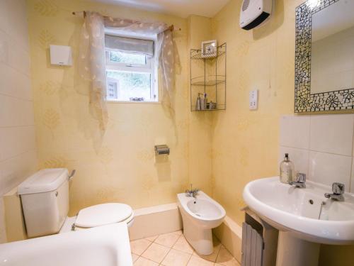 a bathroom with a white toilet and a sink at 52 Fernhill Heights in Bridport