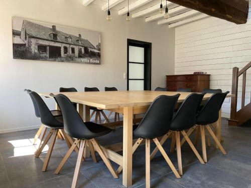 een eetkamer met een houten tafel en zwarte stoelen bij Villa Verger vakantiewoning 12 personen in Cilly