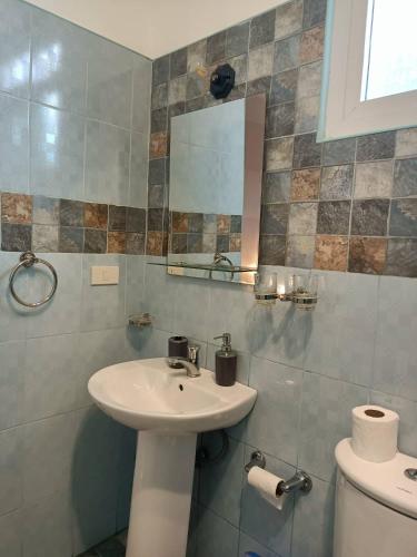 a bathroom with a sink and a mirror and a toilet at Villa Skanderbeg Guest House in Puerto Princesa City