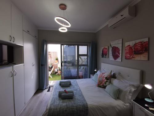 a bedroom with a large bed and a large window at Protea Suite in Bellville