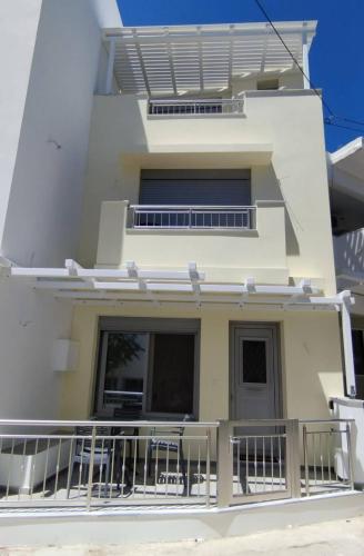 a white apartment building with a balcony at Cosy in Kardamaina