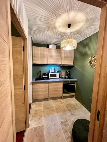 une cuisine avec des murs verts et un plafond dans l'établissement CALANQUE DE PORT MIOU, à Cassis