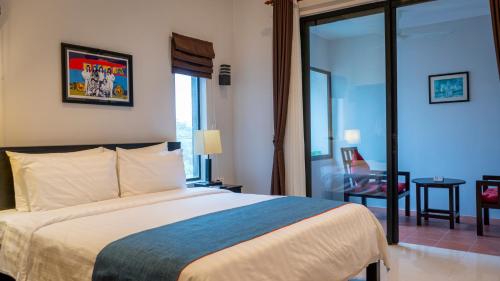 a hotel room with a bed and a glass door at Grange in Siem Reap