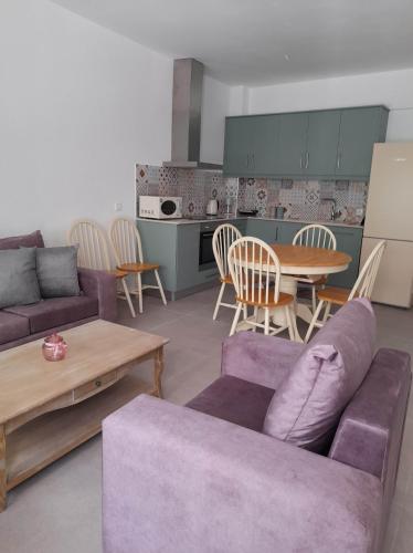 Una sala de estar con un sofá morado y una mesa. en Cosy, en Kardamaina