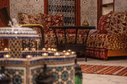 a living room with a couch and a table with candles at Riad bel kayed in Fès