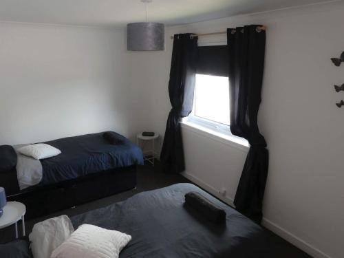 a room with two beds and a window at Dumfries Apartment in Dumfries