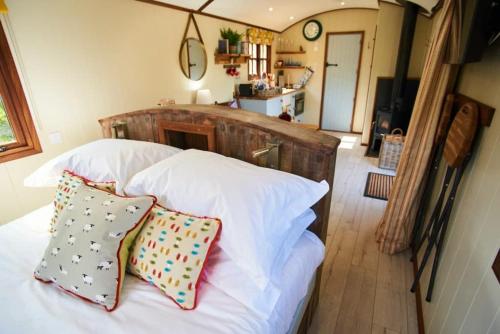 a bedroom with a white bed with two pillows at Beech Shepherds Hut in Dittisham