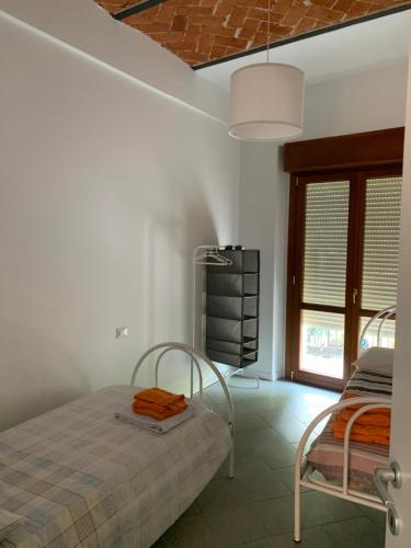 a white bedroom with a bed and a window at I Platani 2 in Montecatini Terme