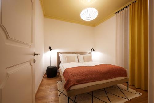 um quarto com uma cama com lençóis brancos e almofadas em Argentieri Apartment em Bolzano
