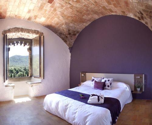 a bedroom with a large bed with a large window at Ses Garites in Pals