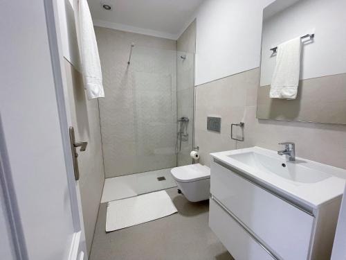 a white bathroom with a sink and a toilet at Edificio Don Diego in Los Cristianos